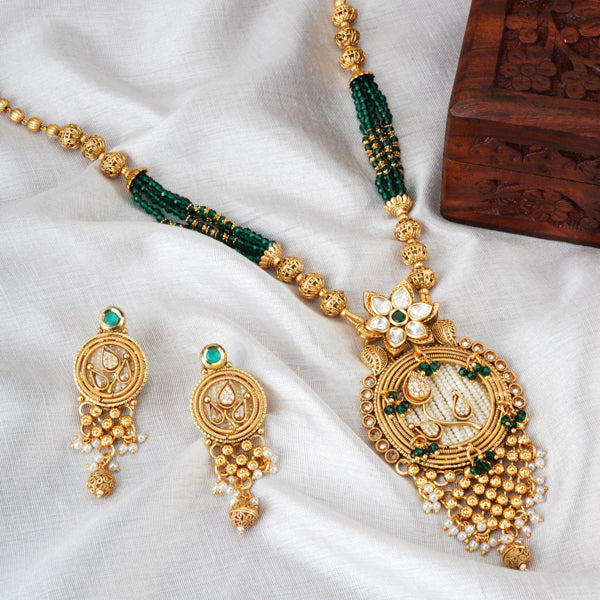 "Stunning gold-tone long necklace set with zircon stones and green beads for a vibrant look."
