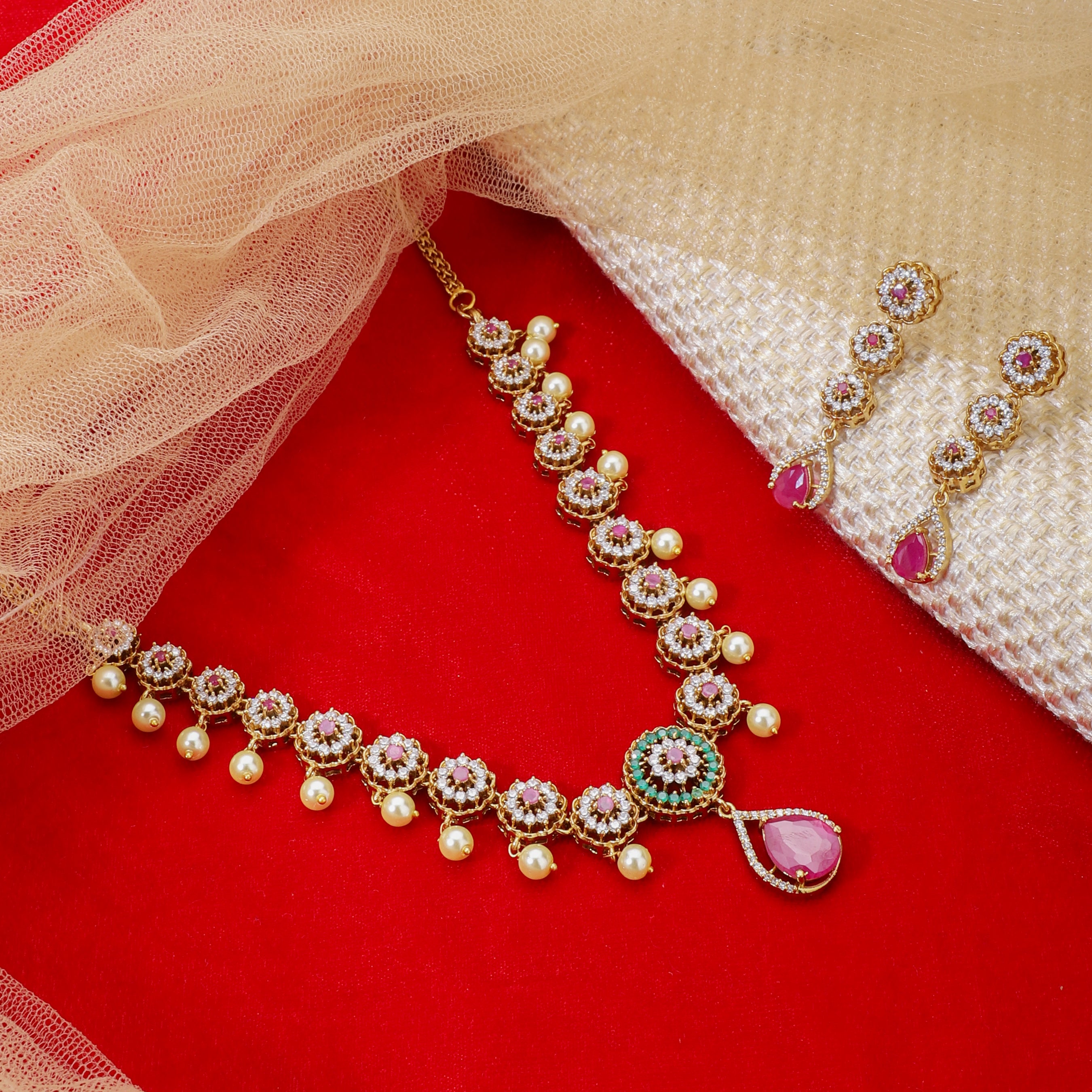 "Elegant gold-tone short necklace set with pink and white zircon stones for a sophisticated touch."
