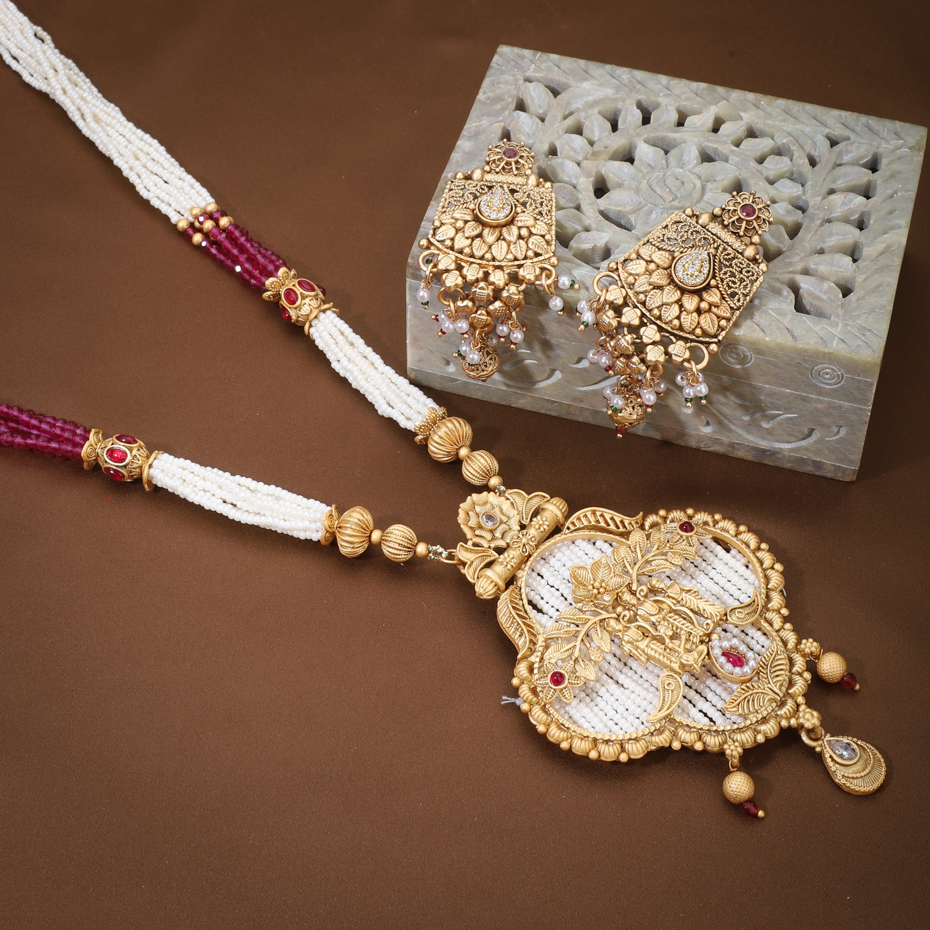 "Golden long necklace set with Ram, Laxman, and Sita design, accented with white and pink pearls."
