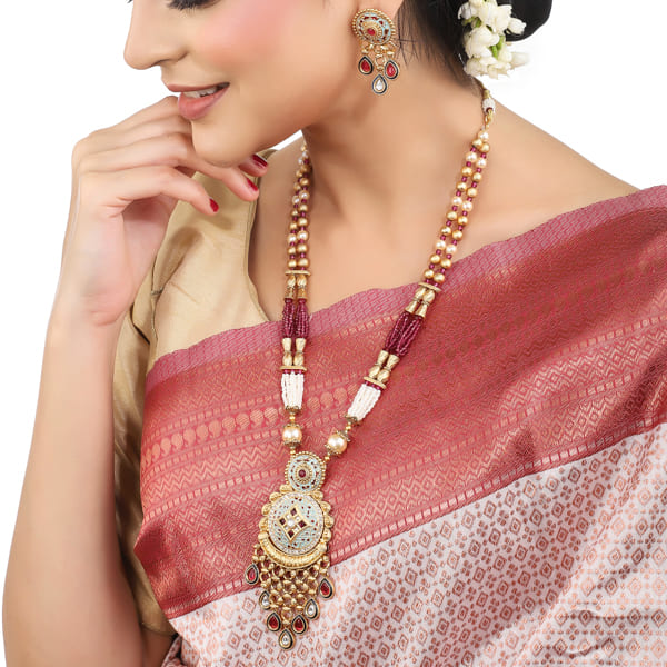 BEAUTIFULLY CRAFTED LONG GOLD-TONE NECKLACE SET FEATURING INTRICATE MEENAKARI DESIGN.