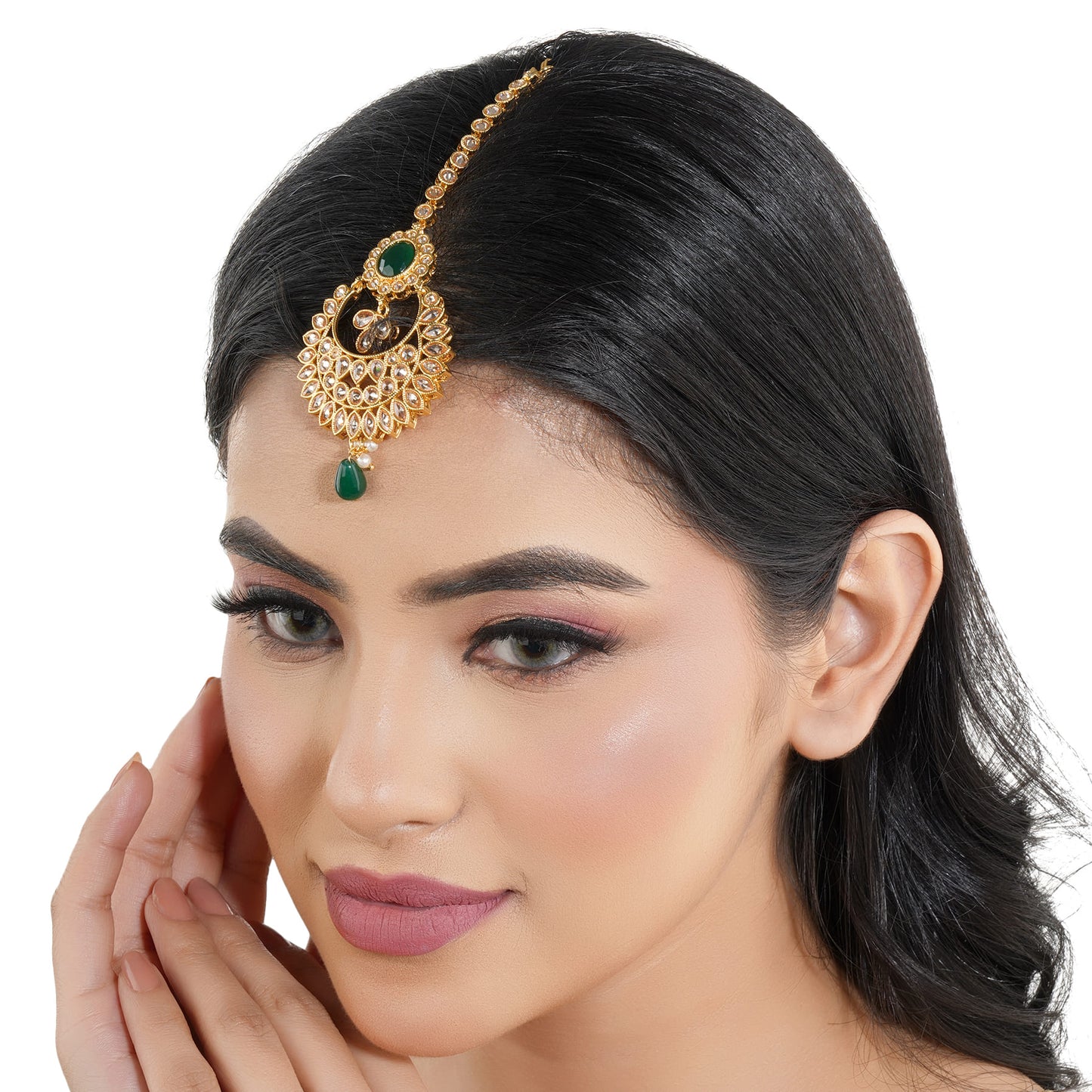 KUNDAN-STUDDED MAANG TIKA FEATURES INTRICATE WORK WITH A SINGLE GREEN PEARL AND A MATCHING STONE.