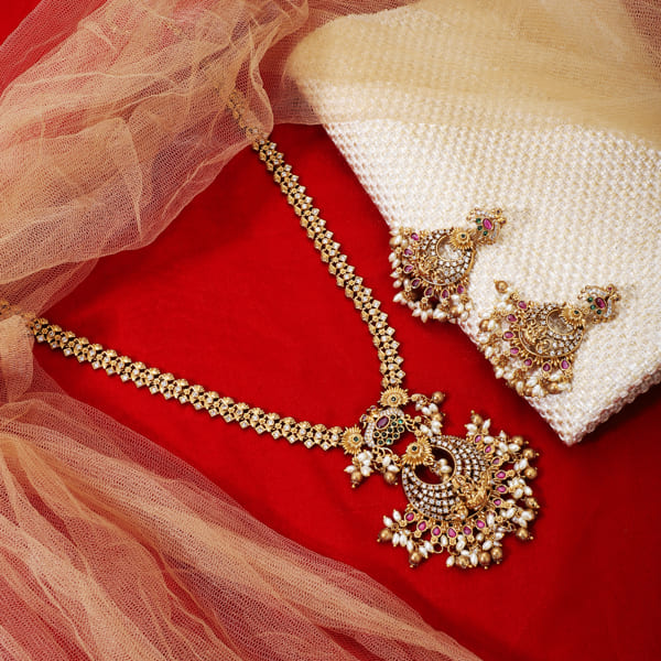 GOLD-TONE LONG NECKLACE SET ADORNED WITH SMALL WHITE PEARLS, ADDING A TOUCH OF CLASSIC ELEGANCE