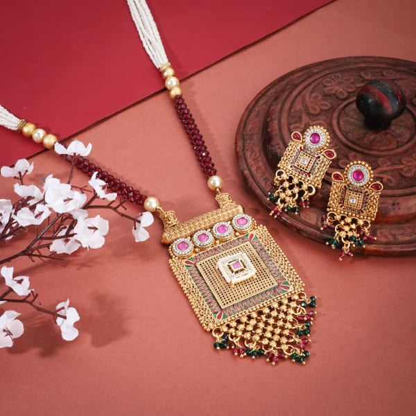 GOLD-TONE LONG NECKLACE SET ADORNED WITH SMALL WHITE PEARLS, ADDING A TOUCH OF CLASSIC ELEGANCE