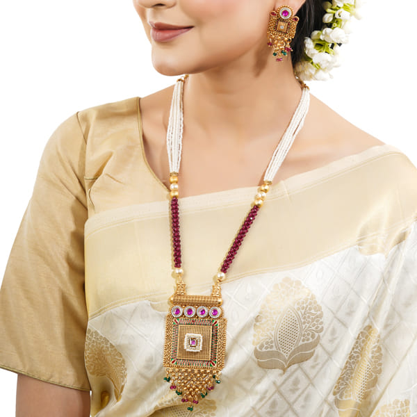 GOLD-TONE LONG NECKLACE SET ADORNED WITH SMALL WHITE PEARLS, ADDING A TOUCH OF CLASSIC ELEGANCE