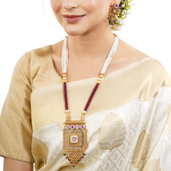 GOLD-TONE LONG NECKLACE SET ADORNED WITH SMALL WHITE PEARLS, ADDING A TOUCH OF CLASSIC ELEGANCE