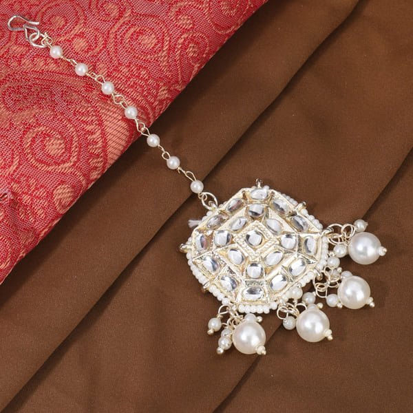 PEARLS-STUDDED MAANG TIKA FEATURES DELICATE PEARLS ARRANGED IN AN ELEGANT DESIGN.