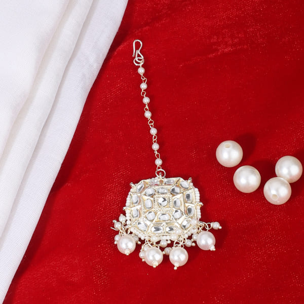 PEARLS-STUDDED MAANG TIKA FEATURES DELICATE PEARLS ARRANGED IN AN ELEGANT DESIGN.