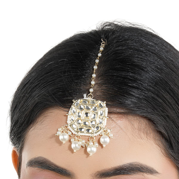 PEARLS-STUDDED MAANG TIKA FEATURES DELICATE PEARLS ARRANGED IN AN ELEGANT DESIGN.