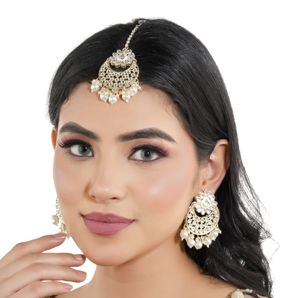 "Classic silver Kundan and pearl-studded earrings with matching Maang Tikka for festive elegance."
