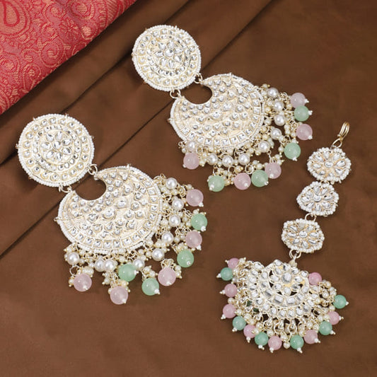 KUNDAN AND PEARL-STUDDED EARRINGS WITH MATCHING MAANG TIKKA, OFFERING A CLASSIC AND ELEGANT SET."