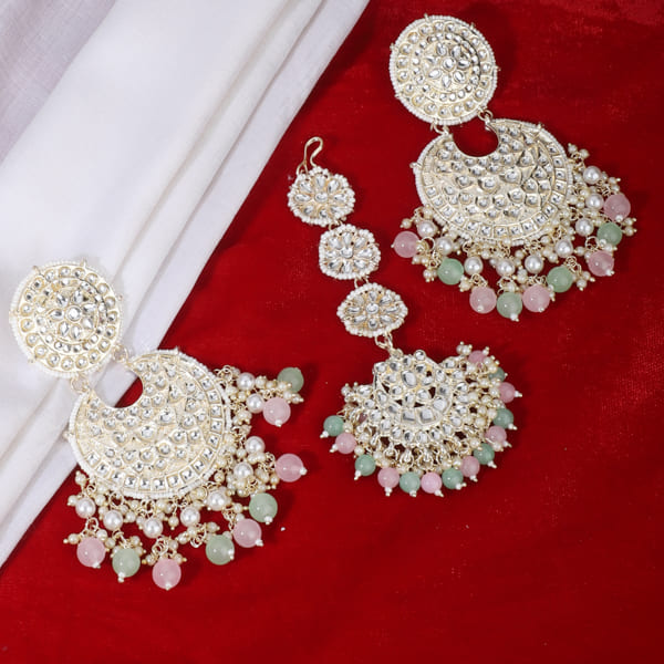 KUNDAN AND PEARL-STUDDED EARRINGS WITH MATCHING MAANG TIKKA, OFFERING A CLASSIC AND ELEGANT SET."