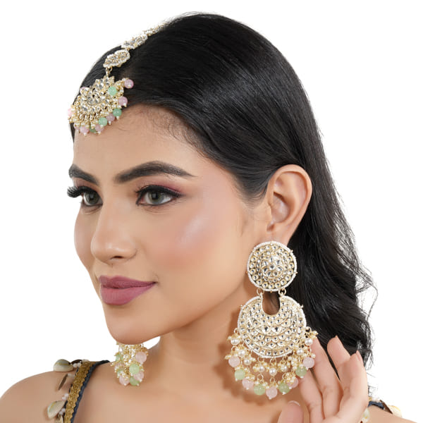 KUNDAN AND PEARL-STUDDED EARRINGS WITH MATCHING MAANG TIKKA, OFFERING A CLASSIC AND ELEGANT SET."