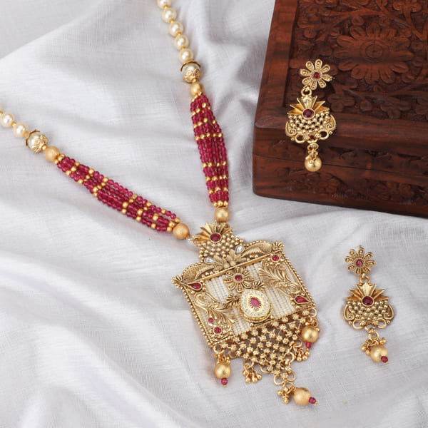 GOLD-TONE LONG NECKLACE SET ADORNED WITH SMALL WHITE PEARLS, ADDING A TOUCH OF CLASSIC ELEGANCE