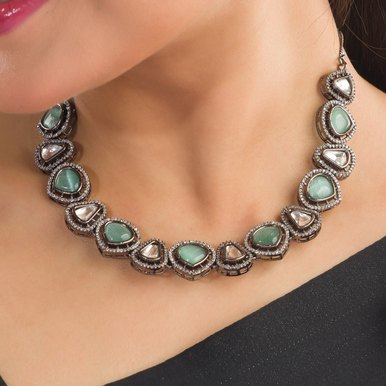 THIS ZIRCON NECKLACE SET FEATURES A STRIKING DESIGN WITH TURQUOISE AND WHITE STONES, ENHANCED BY A SLEEK BLACK POLISH.