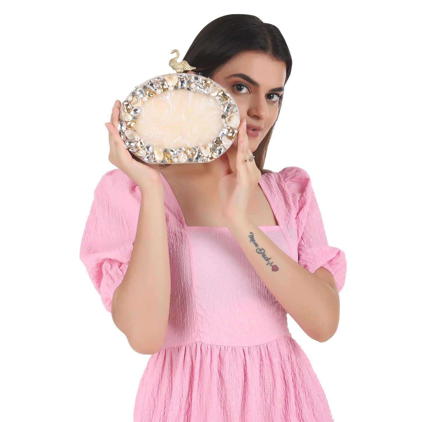 OVAL-SHAPED RESIN CLUTCH, ADORNED WITH BEAUTIFUL STONES AND FEATURING A STRIKING PEACOCK DESIGN CLOSURE. COMPLETE WITH A SLEEK SLING CHAIN,