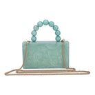 Green resin clutch with velvet lining, heavy-duty sling, and extra pocket for stylish storage.
