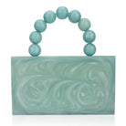 Green resin clutch with velvet lining, heavy-duty sling, and extra pocket for stylish storage.
