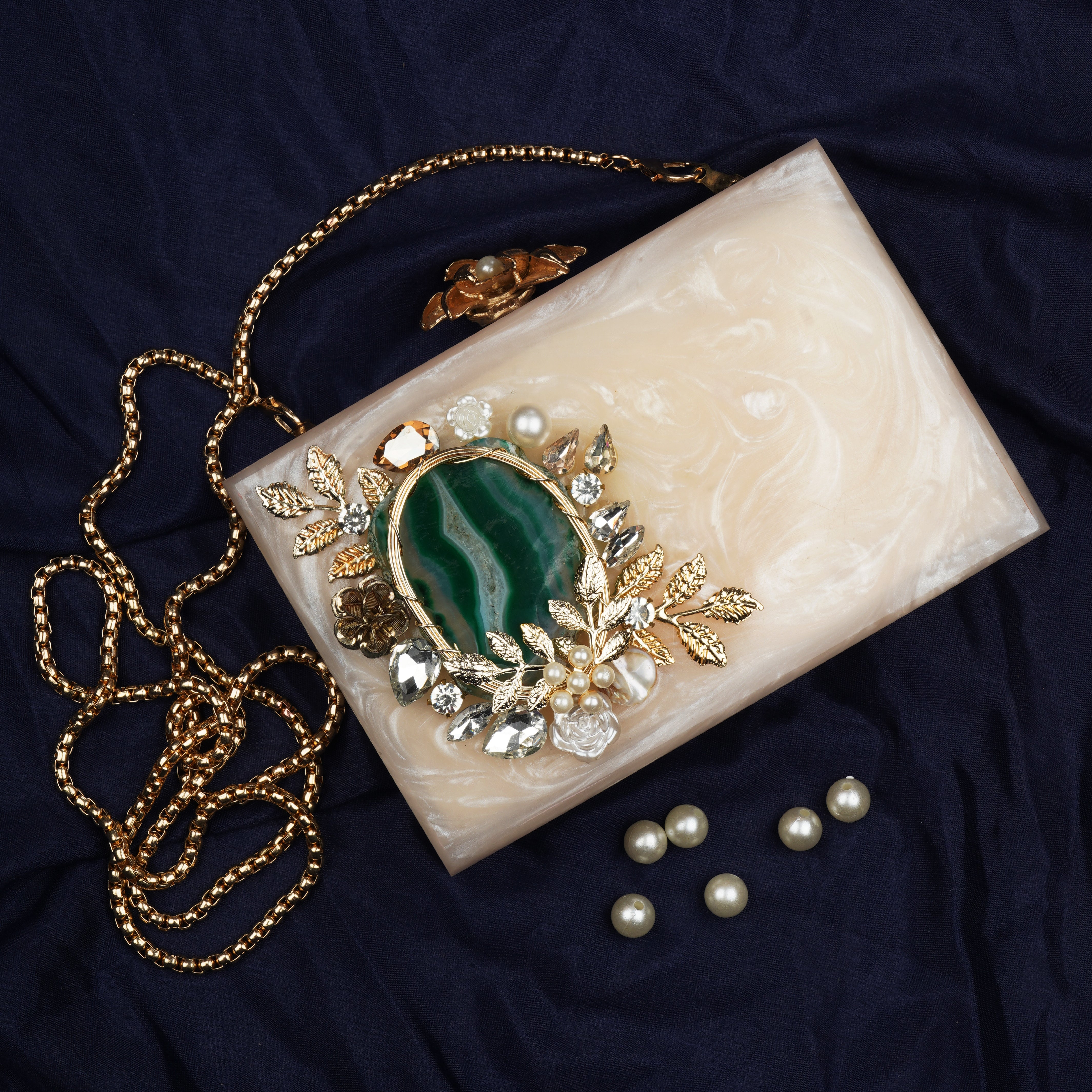 Resin clutch with captivating green agate stone, paired with a stylish sling chain for elegance.
