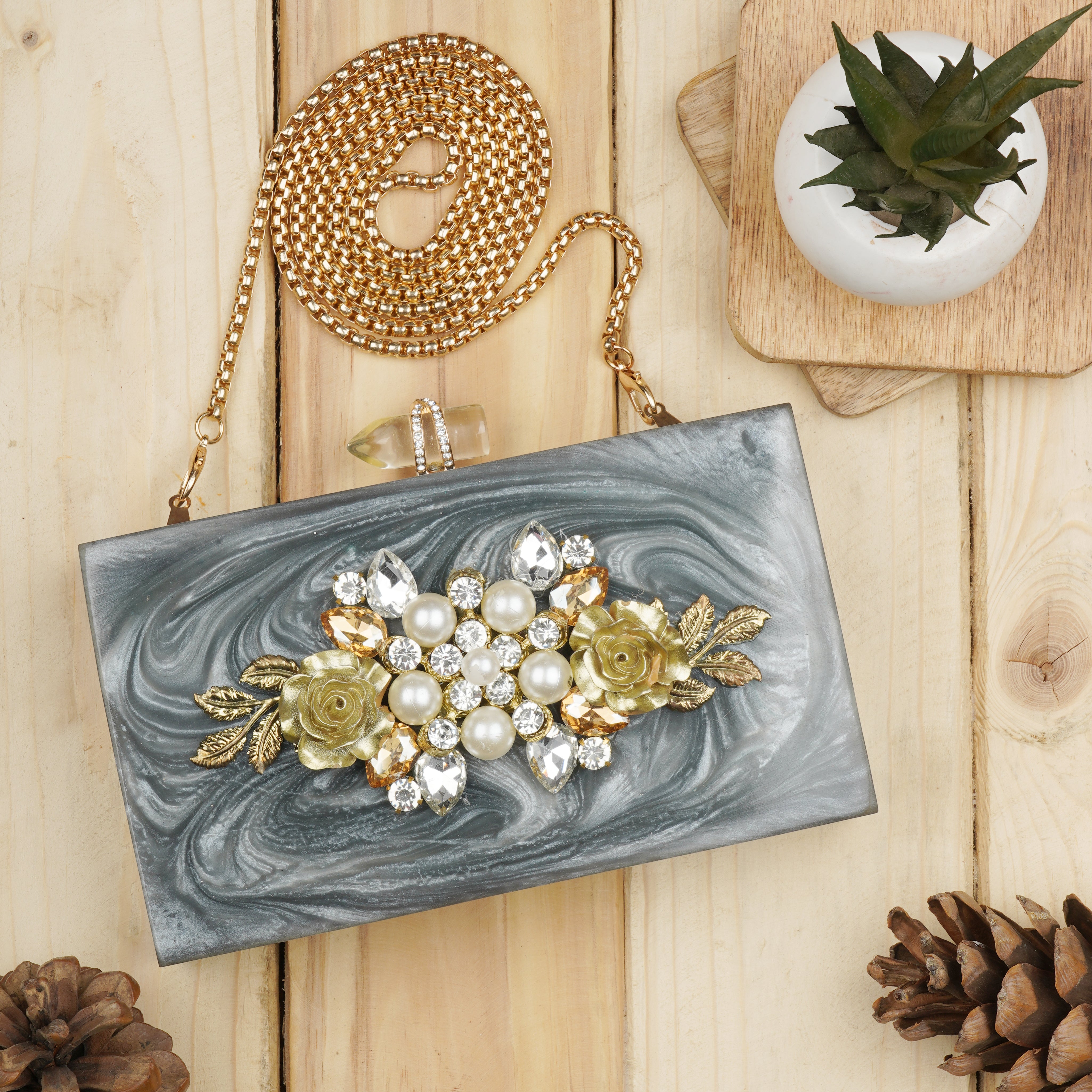 Exclusive grey resin clutch with heavy sling, soft elastic lining, and extra pocket for convenience.
